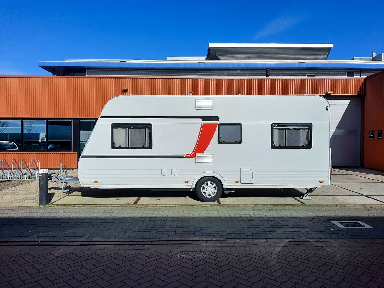 Witte caravan voor een bedrijfspand